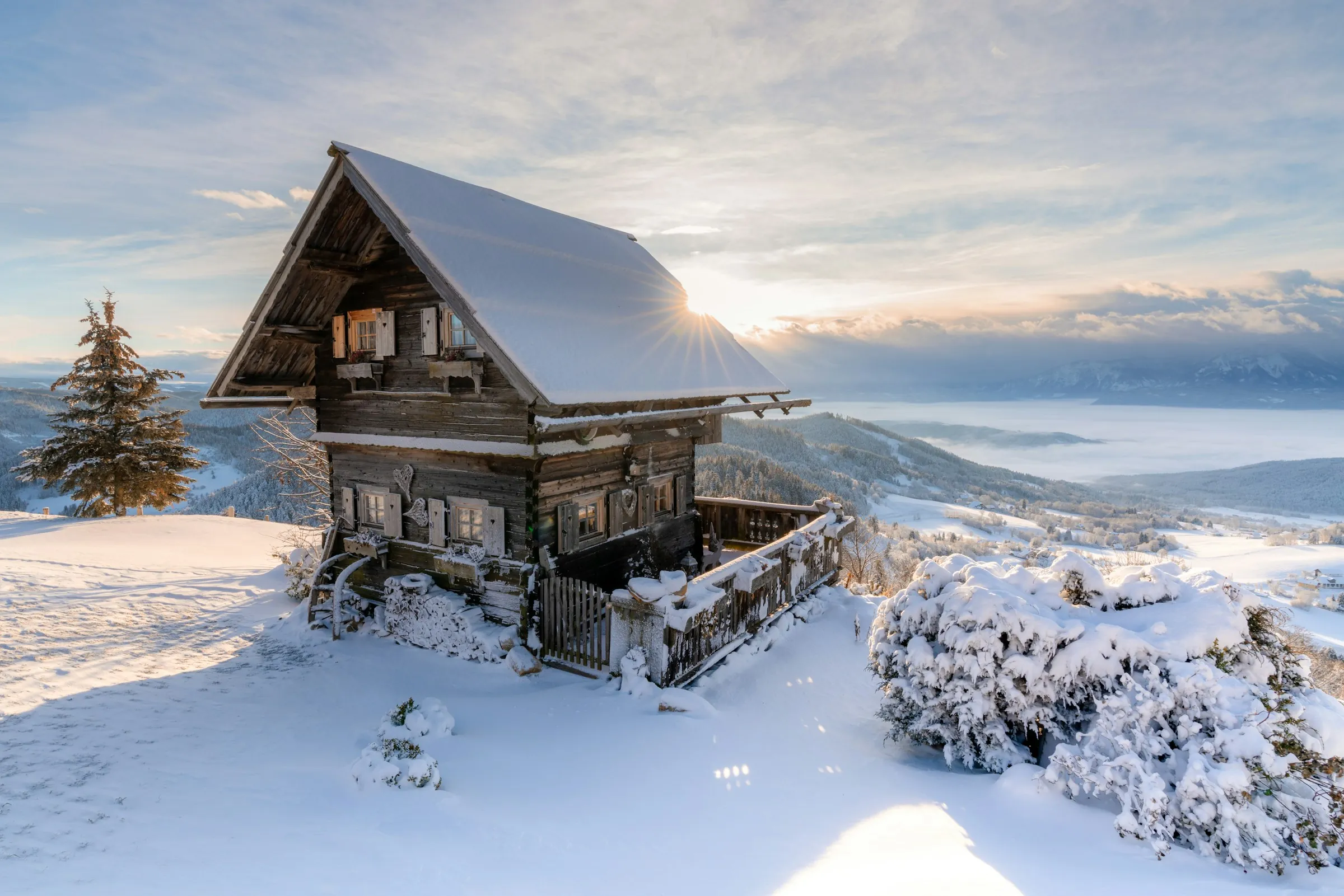 Vieux chalet de bois sous la neige, face aux sommets