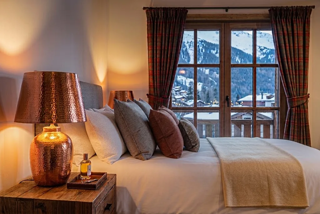 Lit fait, linge blanc et plaid en laine, vue sur la montagne