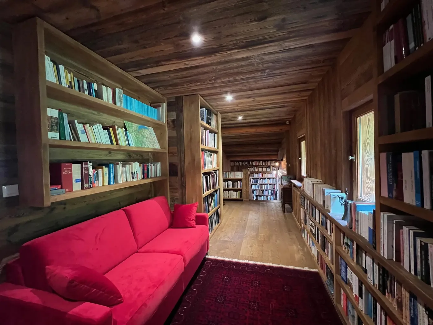 Bibliothèque en vieux bois et canapé rouge