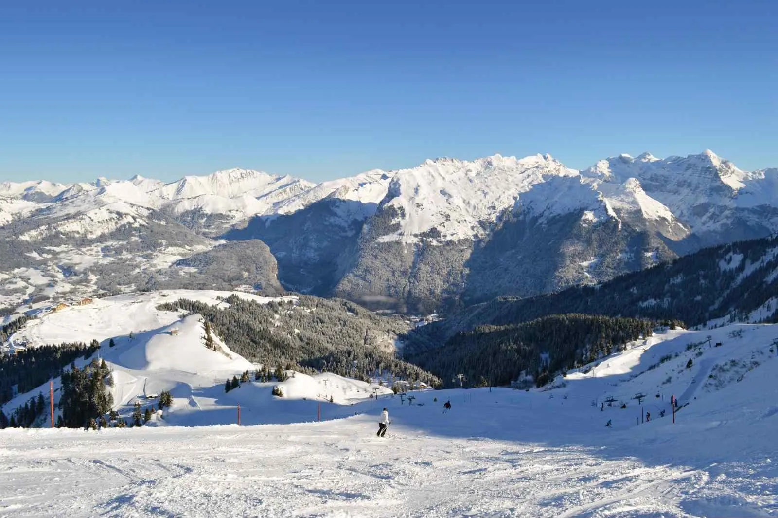 Le domaine skiable au-dessus de Vercland en hiver, face aux sommets enneigés