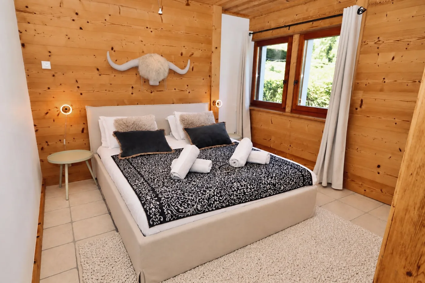 Chambre lambrissée, lit double et linge prêt pour les voyageurs